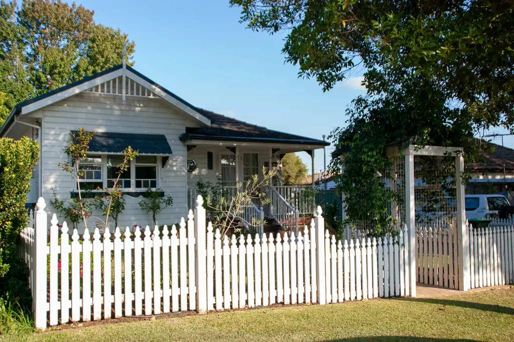 A white picket fence in front of a house