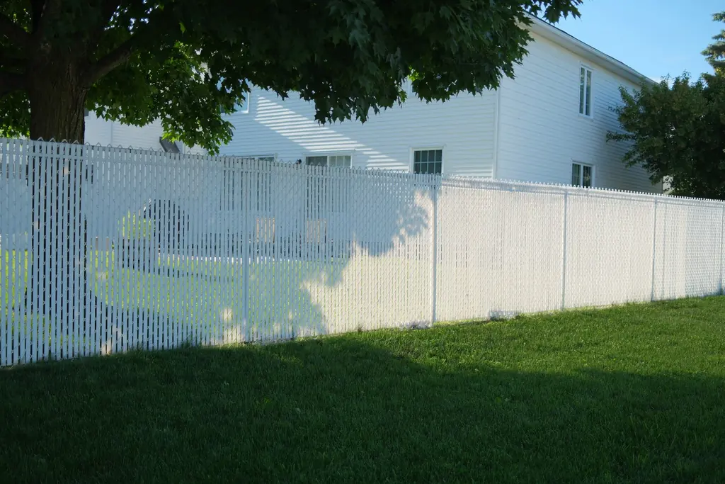A white vinyl fence around a backyard